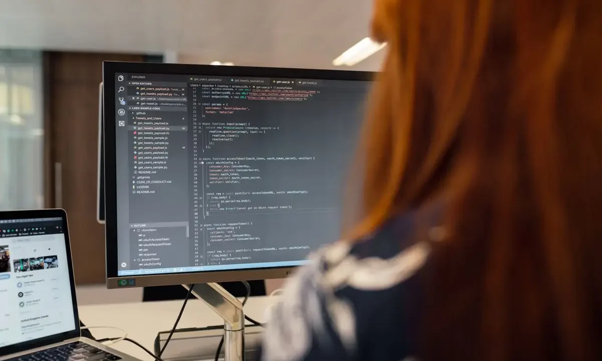 Engineer writing code at a desk in a modern office