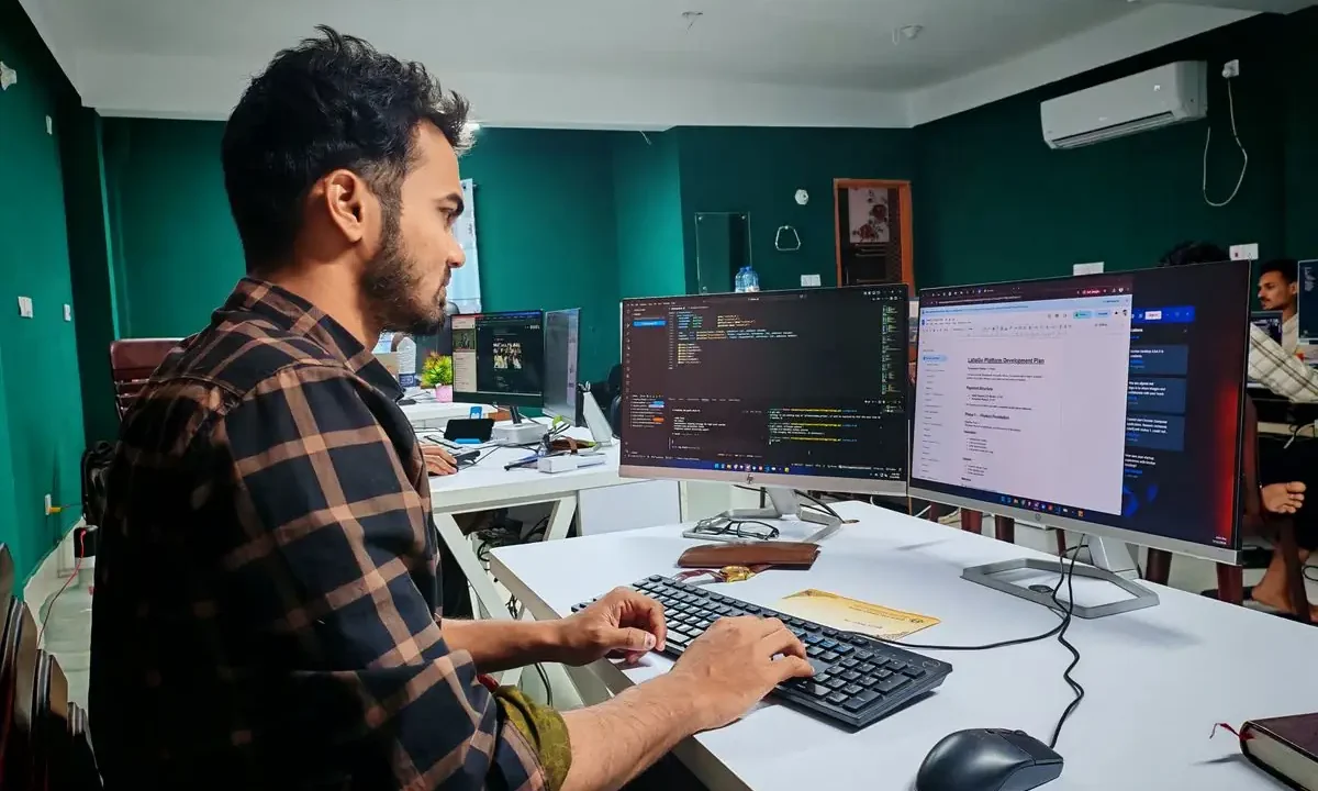 Developer working on code across two monitors