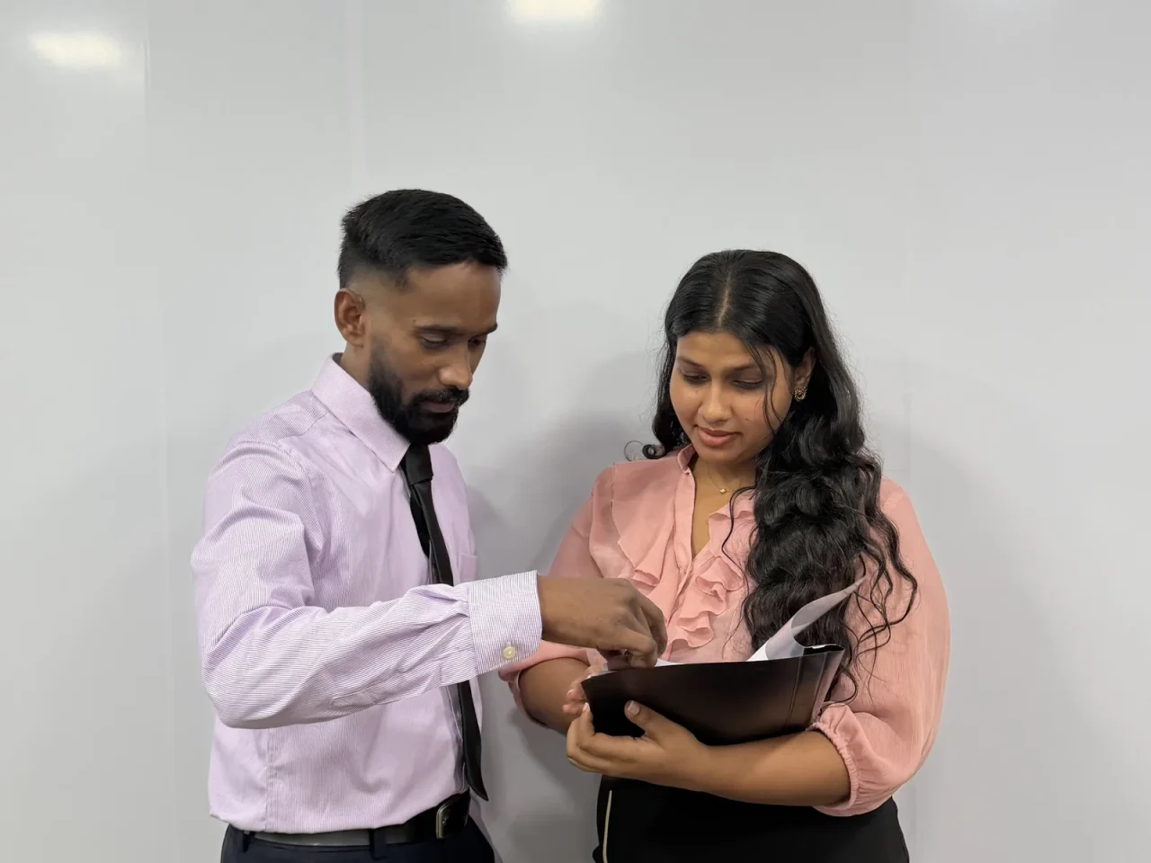 Two colleagues going through work on a tablet together